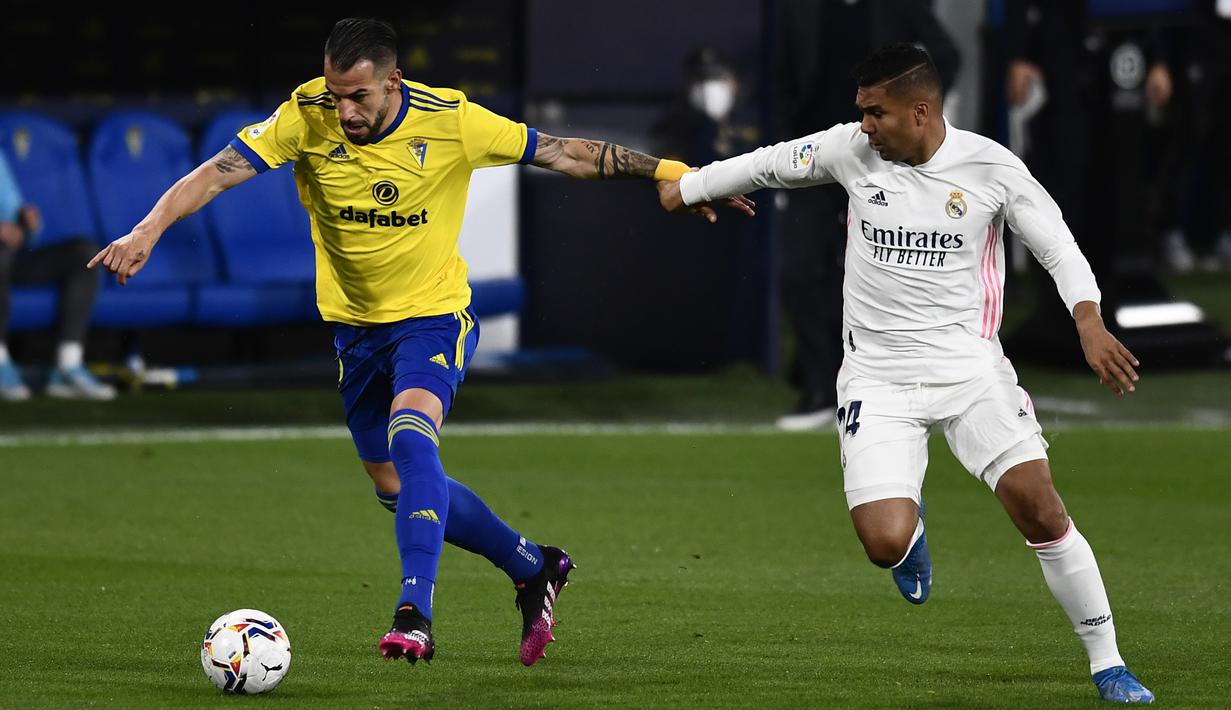 Pemain Cadiz Alvaro Negredo (kiri) berebut bola dengan pemain Real Madrid Casemiro pada pertandingan La Liga Spanyol di Stadion Ramon Carranza, Cadiz, Spanyol, Rabu (21/4/2021). Real Madrid menang 3-0. (AP Photo/Jose Breton)