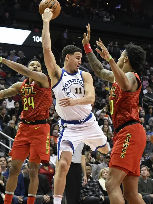 Pemain Warriors, Klay Thompson #11 memberikan umpan kepada rekannya saat diadang dua pemain Atlanta Hawks pada laga NBA basketball game  di Philips Arena, Atlanta, (2/3/2018). Warriors menang 114-109. (AP/John Amis)