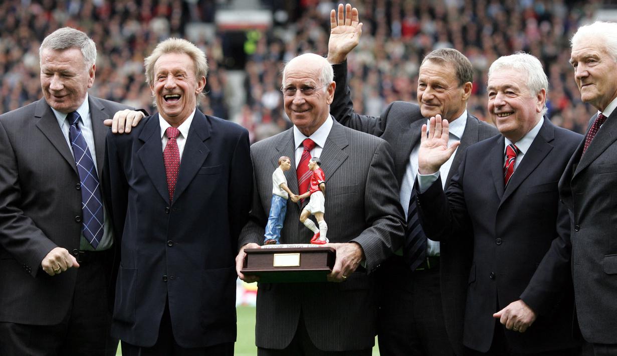 <p>Sir Bobby Charlton (tengah) sering dianggap sebagai inspirasi dan ikon Manchester United. Ia merupakan sosok yang selamat dari kecelakaan udara di Muncih pada 1958. Selama 17 tahun di Old Trafford, Charlton berhasil mempersembahkan 3 gelar Liga Inggris dan 1 trofi Liga Champions. (AFP/Andrew Yates)</p>