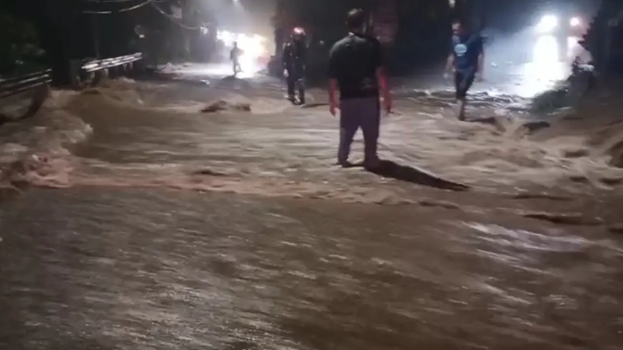 Aliran sungai meluap ke jalan raya di Desa Jelun Banyuwangi, akibat intensitas hujan yang cukup lebat yang menyebabkan akses jalan dari kota Banyuwangi menuju kawasan wisata Kawah Ijen lumpuh pada Kamis malam (22/5/2025) (Istimewa)