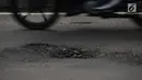 Kondisi jalan berlubang di Jalan Gunung Sahari, Jakarta, Selasa (9/4). Meskipun sudah dilakukan penambalan, jalan raya tersebut sering rusak akibat beban kendaraan yang melintas di atasnya dan intensitas hujan yang belakangan ini cukup tinggi. (merdeka.com/Imam Buhori)