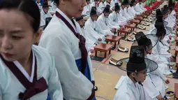 Sejumlah pelajar mengenakan kostum tradisional Korsel saat upacara Hari Kedewasaan di Namsan Hanok Village, Seoul, Senin (15/5). Di usia 20, mereka diperbolehkan merokok, mengonsumsi minuman beralkohol, dan mengikuti pemilihan umum. (Ed JONES/AFP)