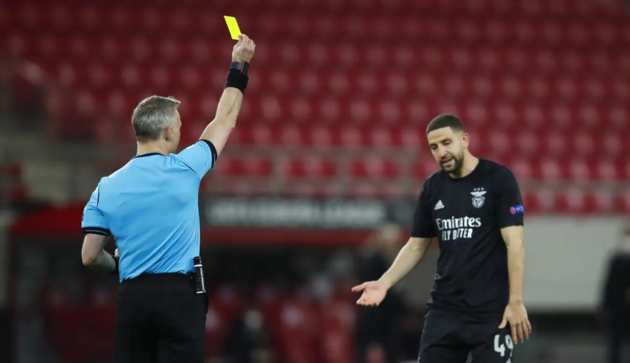 Wasit Bjorn Kuipers menunjukkan kartu kuning kepada pemain Benfica Adel Taarabt pada leg kedua babak 32 besar Liga Europa di Stadion Georgios Karaiskakis, Piraeus, Athena, Yunani, Kamis (25/2/2021). Arsenal menang 3-2 dan lolos ke babak 16 besar. (AP Photo/Thanassis Stavrakis)