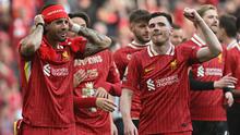 Pemain Liverpool, Dominik Szoboszlai (kiri) merayakan kemenangan timnya bersama Andrew Robertson setelah memastikan gelar juara Liga Inggris 2024/2025 di Anfield, Liverpool, Inggris, Minggu (27/04/2025) waktu setempat. (AFP/Paul Ellis)