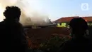 Asap hitam membumbung dari atas Gudang JNE Express yang terbakar di Jalan Pekapuran Raya, Depok, pada Senin (12/9/2022). Hingga berita ini diturunkan, proses pemadaman api masih berlangsung di gudang JNE di Depok. (Liputan6.com/Herman Zakharia)