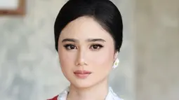 Pemeran Nur dalam film KKN di Desa Penari ini tampil paripurna dengan kebaya berwarna putih dan selendang merah, lengkap dengan bros dari Chanel. Dengan penampilannya tersebut, banyak netizen yang menyebut kalau Tissa Biani sudah punya vibes seperti seorang ibu pejabat. (Liputan6.com/IG/@tissabiani)