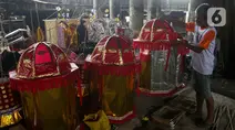 Perajin membuat replika barang-barang untuk sembahyang yang terbuat dari kertas di Kolong Tol Gedong Panjang, Jakarta, Senin (20/1/2025). (Liputan6.com/Herman Zakharia)