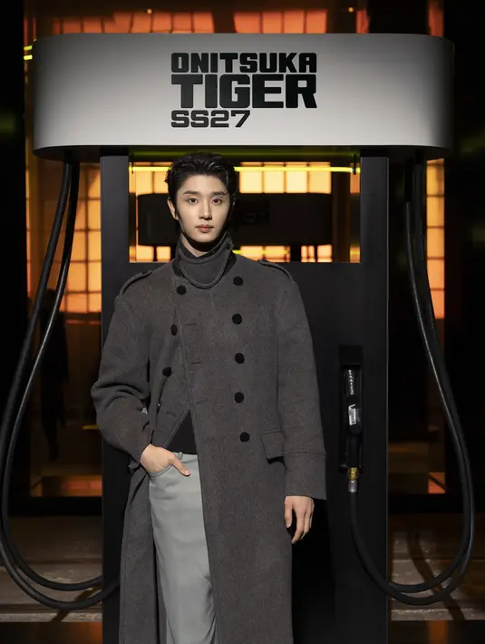 Kim Jaewon terlihat gagah dengan long coat abu-abu gelap berkerah tinggi, dipadukan celana abu-abu muda dan sneakers motif kulit ular [dok. Onitsuka Tiger]