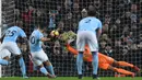 Aksi pemain Manchester City, Sergio Aguero mencetak gol lewat titik putih pada laga Premier League di Etihad Stadium, Manchester, (20/1/2018). Manchester City menang 3-1. (AFP/Paul Ellis)