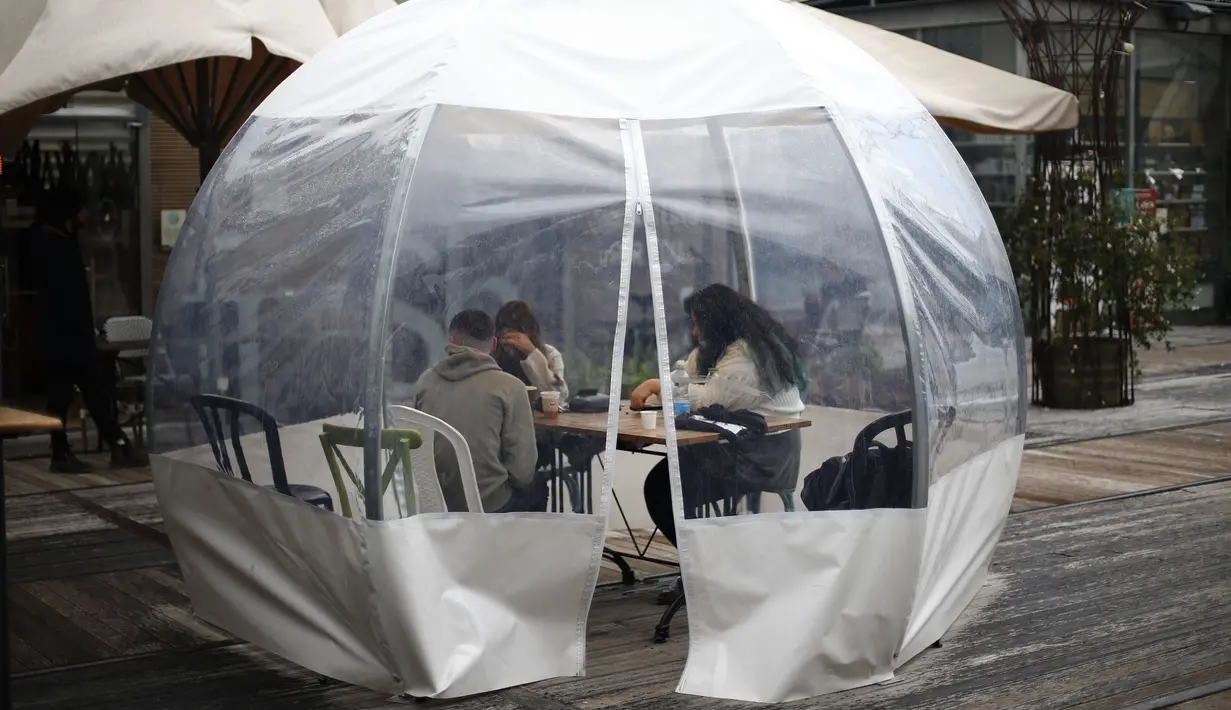 Sejumlah orang menyantap makanan di sebuah dining bubble, instalasi tempat makan berbentuk gelembung, di luar ruangan di Yerusalem pada 26 November 2020. Tempat makan di luar ruangan menjadi langkah yang diadopsi secara luas oleh banyak restoran untuk mengatasi pandemi COVID-19 (Xinhua/Muammar Awad)