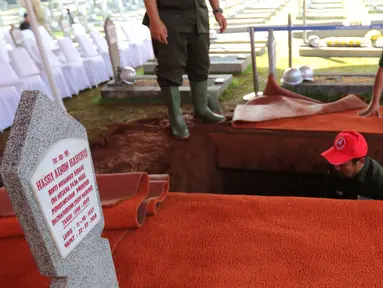 Pekerja menggali makam Presiden ke-3 RI BJ Habibie di TMP Kalibata, Jakarta, Kamis (12/9/2019). Makam Habibie bersebelahan dengan sang istri tercinta, Ainun Habibie. (Liputan6.com/Herman Zakharia)