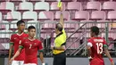 Wasit Turki Alkhudhayr memberi kartu kuning kepada Syaiful Indra Cahya (4) setelah melanggar pemain Kamboja U-23 di kotak penalti yang berbuah tendangan penalti bagi Kamboja U-23. (Bola.com/Arief Bagus)