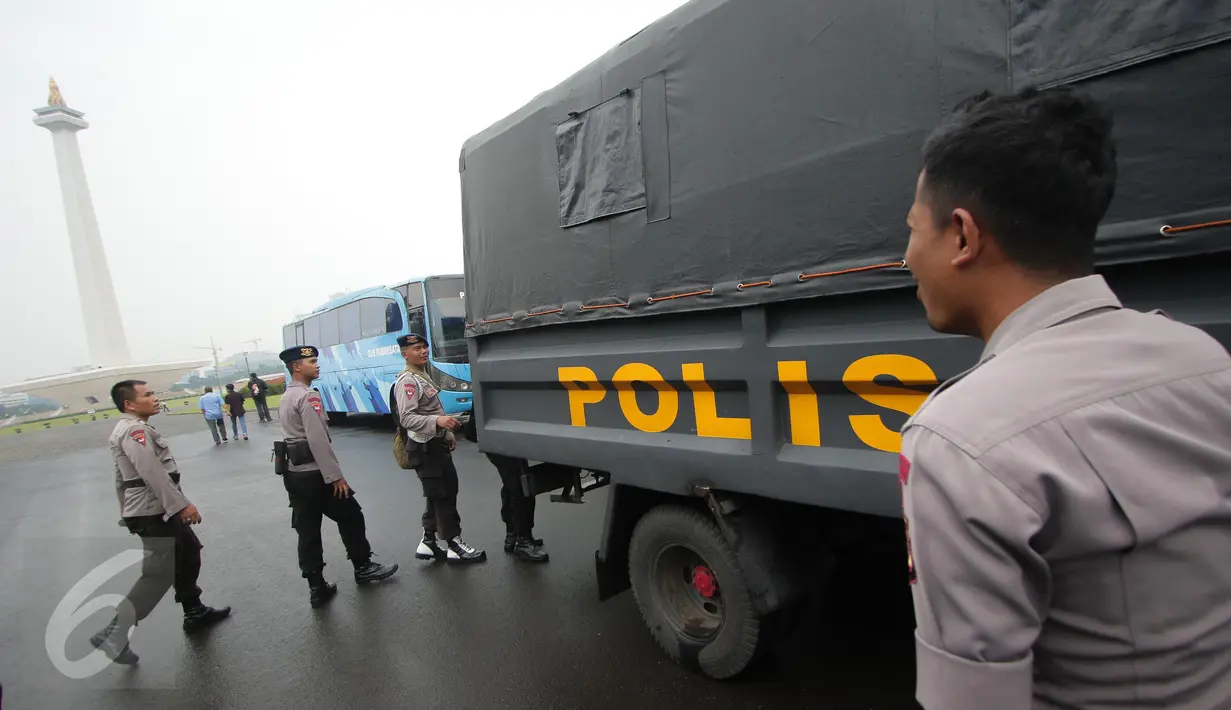Petugas kepolisian menaiki truk pengangkut saat melakukan pengamanan di kawasan Monas, Jakarta, Selasa (18/4). Polda Metro Jaya dan Kodam Jaya mengerahkan 64.523 personel gabungan untuk mengawal Pilkada DKI 2017 putaran kedua. (Liputan6.com/Faizal Fanani)