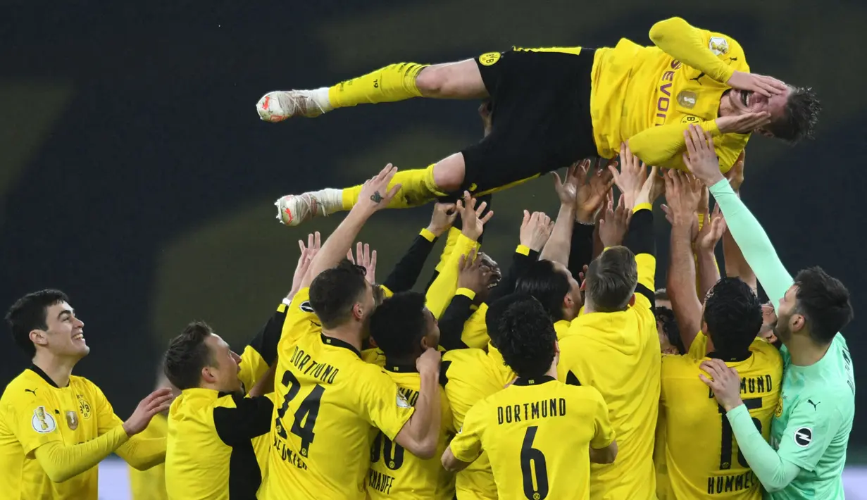 Bek Borussia Dortmund, Lukasz Piszczek dilemparkan rekan-rekannya ke udara usai berakhirnya laga final DFB Pokal 2020/2021 melawan RB Leipzig di Olympiastadion, Berlin, Kamis (13/5/2021). Dortmund menang 4-1 atas Leipzig dan menjadi juara. (AFP/Annegret Hilse/Pool)