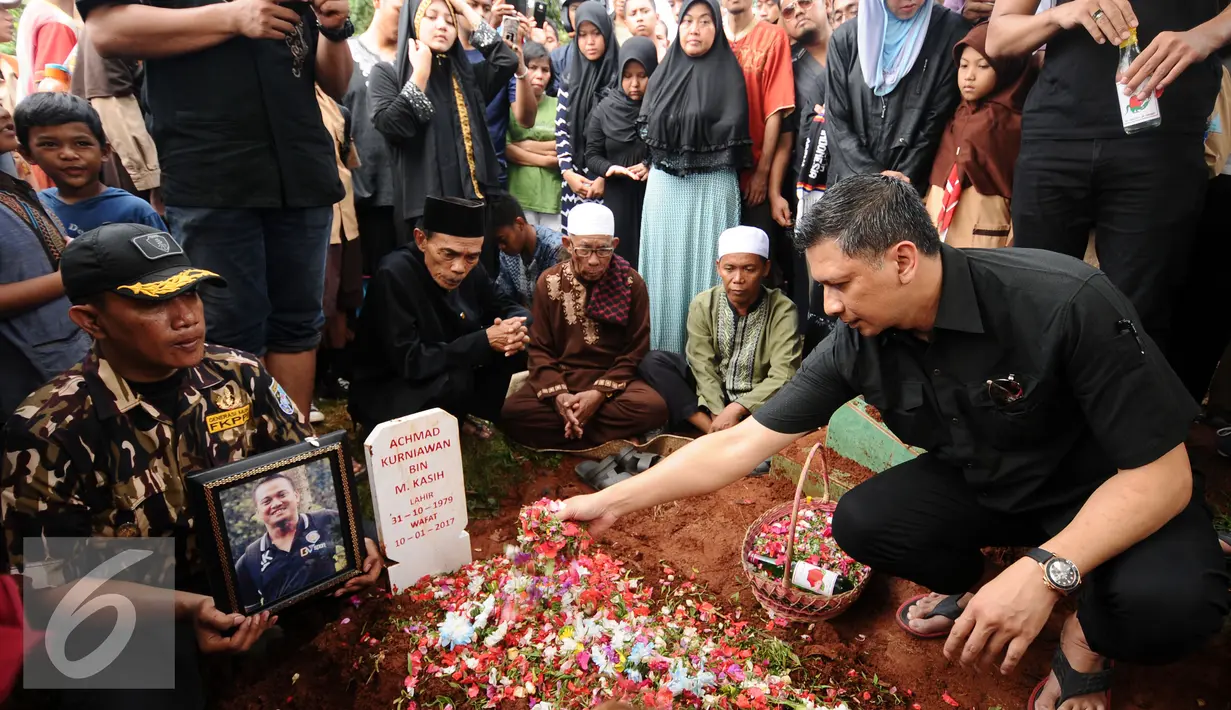 Wakil Ketua PSSI, Iwan Budianto menabur bunga di makam penjaga gawang Arema FC Achmad Kurniawan di TPU Kalisari di kawasan Cijantung, Jakarta, Rabu (11/1). Kiper Arema FC, Achmad Kurniawan wafat di usia 37 tahun. (Liputan6.com/Helmi Fithriansyah)