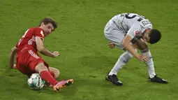 Pemain Bayern Munchen Thomas Mueller (kiri) berebut bola dengan pemain Bayer Leverkusen Exequiel Palacios pada pertandingan Bundesliga di Stadion Allianz Arena, Munchen, Jerman, Selasa (20/4/2021). Bayern Munchen menang 2-0. (Christof Stache, Pool via AP)