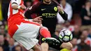 Gelandang Arsenal, Francis Coquelin berusaha melewati gelandang Manchester City, David Silva pada lanjutan liga Inggris di stadion Emirates, London, (2/4). Arsenal bermain imbang 2-2 dengan City. (AP Photo/Alastair Grant)