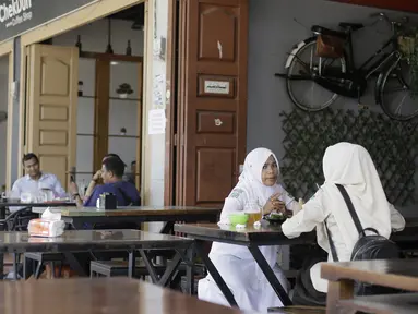 Pengunjung duduk di sebuah restoran di Bireuen, Aceh, Rabu (5/9). Pemerintah Kabupaten Bireuen mengharamkan perempuan dan lelaki yang nonmuhrim minum kopi semeja di restoran, kafe, bahkan di warung kopi biasa. (AFP PHOTO/AMANDA JUFRIAN)