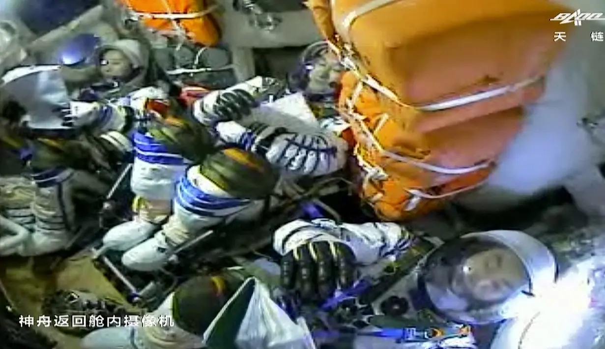 Tangkapan layar menunjukkan (kiri-kanan) astronot China Wang Yaping, Zhai Zhigang, dan Ye Guangfu berada dalam kapsul pesawat ruang angkasa Shenzhou-13 sebelum mendarat di Mongolia Dalam, China, 16 April 2022. (CCTV/AFP)