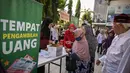 Seorang wanita lanjut usia menerima bantuan uang tunai di masjid Cheng Hoo, Surabaya, Jawa Timur pada Rabu 4 Maret 2026. Ribuan warga Kota Surabaya memadati kawasan Masjid Muhammad Cheng Hoo, Surabaya, Jawa Timur, untuk menerima penyaluran zakat mal. (JUNI KRISWANTO/AFP)