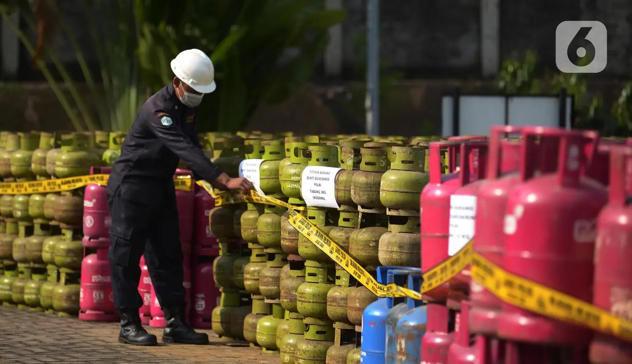 Petugas memasang garis polisi di dekat tabung LPG bersubsidi  di Jakarta, Jumat (15/7/2022). Direktorat Tindak Pidana Tertentu (Dirtipidter) Bareskrim Polri menggelar perkara kasus penyalahgunaan LPG bersubsidi dengan cara menyuntikkan gas 3 kilogram bersubsidi ke tabung gas ukuran 5,5 kilogram, 12 kilogram, dan 50 kilogram. (merdeka.com/Imam Buhori)