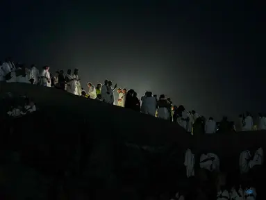 Umat Muslim berkumpul di bukit berbatu yang dikenal sebagai Jabal Rahmah atau Gunung Rahmat, di Dataran Arafah, selama ibadah haji tahunan di dekat kota suci Mekah, Arab Saudi, Selasa 26 Mei 2026. (AP Photo/Altaf Qadri)