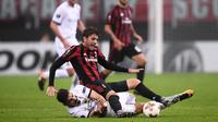 Gelandang AC Milan, Manuel Locatelli, berebut bola dengan gelandang AEK Athens, Lazaros Christodoulopoulos, pada laga Liga Europa di Stadion San Siro, Milan, Kamis (19/10/2017). AC Milan bermain imbang 0-0 dengan AEK Athens. (AFP/Marco Bertorello)