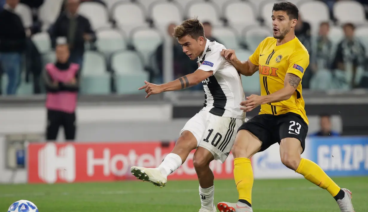 Pemain Juventus, Paulo Dybala (kiri) menendang bola saat bertanding melawan Young Boys dalam laga Grup H Liga Champions di Stadion Allianz, Turin, Italia, Selasa (2/10). Juventus membungkam Young Boys 3-0 lewat hattrick Dybala. (AP Photo/Luca Bruno)