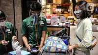 Pengunjung menggunakan kantong belanja ramah lingkungan saat berbelanja di Mall Grand Indonesia, Jakarta, Rabu (1/7/2020). Hari pertama larangan penggunaan kantong plastik di Jakarta, pusat perbelanjaan ini menerapkan penggunaan kantong belanja ramah lingkungan (KBRL). (Liputan6.com/Faizal Fanani)
