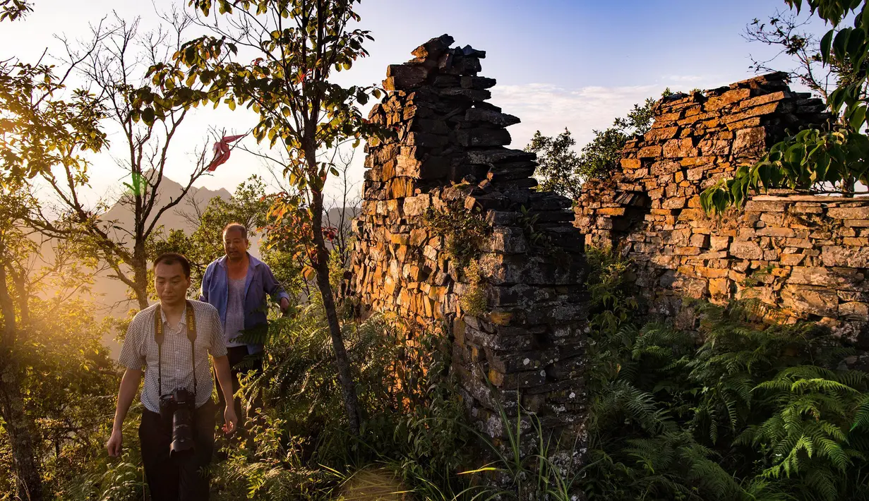 Para wisatawan mengunjungi peninggalan kompleks desa kuno di Minzhu, sebuah kota di Wilayah Langao, Provinsi Shaanxi, China pada 29 Juni 2020. Terletak di daerah pegunungan di Gunung Bashan, peninggalan kompleks desa tersebut berasal dari masa Dinasti Ming (1368-1644). (Xinhua/Tao Ming)