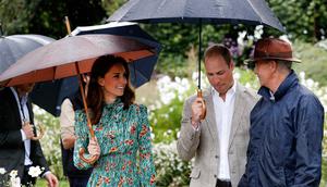Pangeran William (tengah) dan Kate Middleton (kiri) dipandu saat berkeliling  di taman Istana Kensington, London, Rabu (30/8). Kate mengenakan gaun yang sesuai dengan acara ini, karena bunga Poppy memiliki simbol “mengingat”. (Kirsty Wigglesworth/AP)