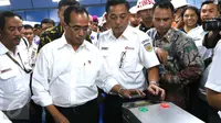 Menhub Budi Karya Sumadi menempelkan e-tiket pada reader gate sebelum naik KRL di Stasiun Juanda, Jakarta, Rabu (10/8). Menhub Budi meninjau proyek pembangunan kereta bandara Soekarno Hatta yang akan terintegrasi dari Jakarta. (Liputan6.com/Angga Yuniar)