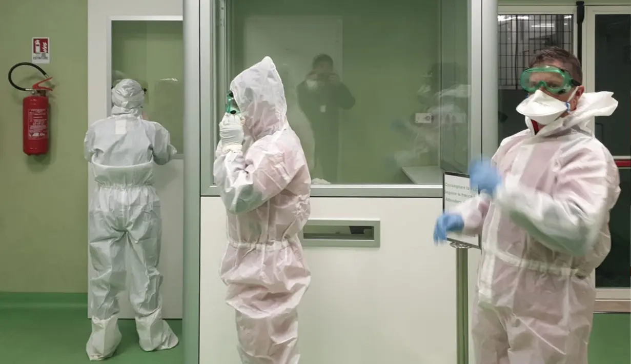 Anggota tim Kementerian Kesehatan Italia bersiap-siap untuk menerapkan langkah-langkah dan prosedur kesehatan terhadap risiko wabah virus corona yang mematikan, setelah penumpang mendarat di bandara Fiumicino Roma, Italia (23/1/2020). (Aeroporto Di Roma/AFP)