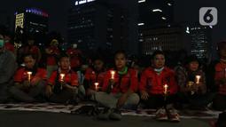 Beberapa peserta aksi unjuk rasa memegang lilin saat doa bersama lintas agama di Kawasan Patung Kuda, Jakarta, Selasa (10/11/2020). Sejumlah massa gabungan dari berbagai organisasi buruh dan mahasiswa berunjuk rasa menolak pengesahan Omnibus Law UU Cipta Kerja. (Liputan6.com/Helmi Fithriansyah)