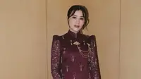 Untuk akad nikah, ia mengenakan kebaya brokat warna maroon dengan model janggan yang memiliki ciri khas kerah tinggi. Kebaya yang dihiasi beads rumbai dipadukan bros rantai warna gold serta bawahan kain batik. Ia juga membawa mini bag lady Dior hitam. [@aaliyahmassaid]