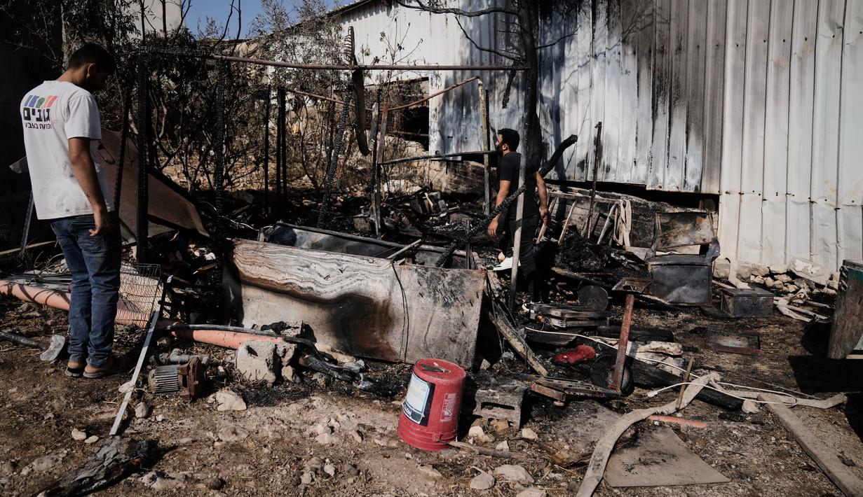 Di Tulkarem, di barat laut Tepi Barat, pemukim Israel melakukan serangan besar-besaran di kawasan industri di timur kota, dekat kota Beit Lid, yang menyebabkan kebakaran besar dan melukai sejumlah warga. Tampak dalam foto, warga Palestina memeriksa kerusakan di kawasan industri setelah serangan yang dilakukan oleh pemukim Israel pada hari sebelumnya di desa Beit Lid, dekat Tulkarm, di Tepi Barat, Rabu 12 November 2025. (AP Photo/Majdi Mohammed)