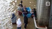 Warga menyusuri banjir yang merendam Jalan Kapten Tendean, Jakarta, Sabtu (20/2/2021).  Banjir yang disebabkan curah hujan tinggi memutus akses lalu lintas di Jalan Kapten Tendean. (merdeka.com/Imam Buhori)