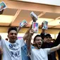 Pelanggan pertama menunjukkan iPhone X setelah ia membelinya di showroom Apple di Sydney, Australia (3/11). Apple iPhone X mulai dijual di Australia dengan antrian panjang di luar toko Apple. (AFP Photo/Saeed Khan)