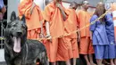 Seekor anjing K-9 berjaga dekat para tersangka saat rilis penyelundupan narkoba jaringan Malaysia di Gedung BNN, Jakarta, Selasa (16/10). BNN membongkar 4 kasus narkoba yang berbeda dengan mengamankan 17 tersangka. (Liputan6.com/Immanuel Antonius)