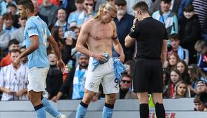 Erling Haaland harus mengganti jersey-nya setelah koyak oleh Gabriel pada duel Manchester City vs Arsenal dalam lanjutan Liga Inggris 2025/2026, Minggu (19/4/2026). (Darren Staples / AFP)