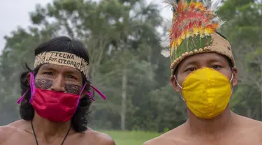 Suku Tikuna berpose mengenakan masker di tengah kekhawatiran virus corona Covid-19 di Leticia, Departemen Amazonas, Kolombia pada 8 Juni 2020. Kasus virus corona ini meningkatkan kekhawatiran akan resiko penyebaran ke masyarakat adat yang rentan dan berada di pedalaman. (Tatiana de NEVO/AFP)