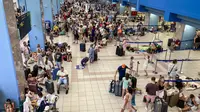 Suasana di bandara lokal di Rhodes, Yunani, dipenuhi para turis yang menunggu dievakuasi. (dok. Will VASSILOPOULOS / AFP)