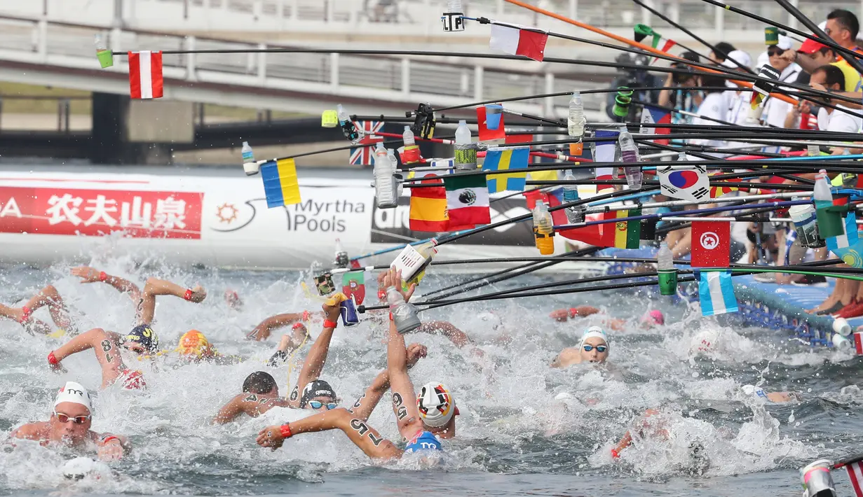 Perenang meraih botol minuman saat berlaga dalam lomba renang air terbuka nomor 10 km putra di Kejuaraan Renang Dunia di Yeosu, Korea Selatan, Selasa (16/7/2019). (HANDOUT/FINA ORGANISING COMMITTEE VIA YONHAP/AFP)