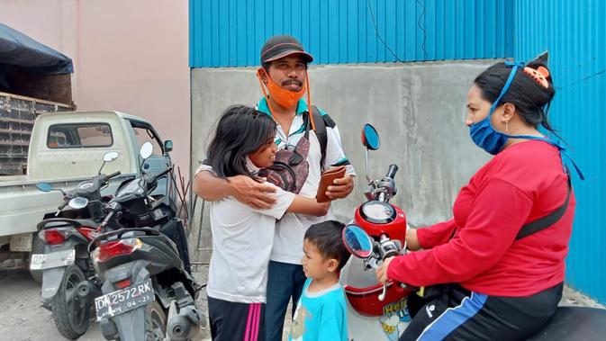 Seorang sukarelawan asal Palu di antar anak dan istrinya ke pangkalan bus PO Sumber Sejahtera untuk berangkat ke Mamuju dan Majene, Sabtu (16/01/2021). (Foto: Heri Susanto/ Liputan6.com).
