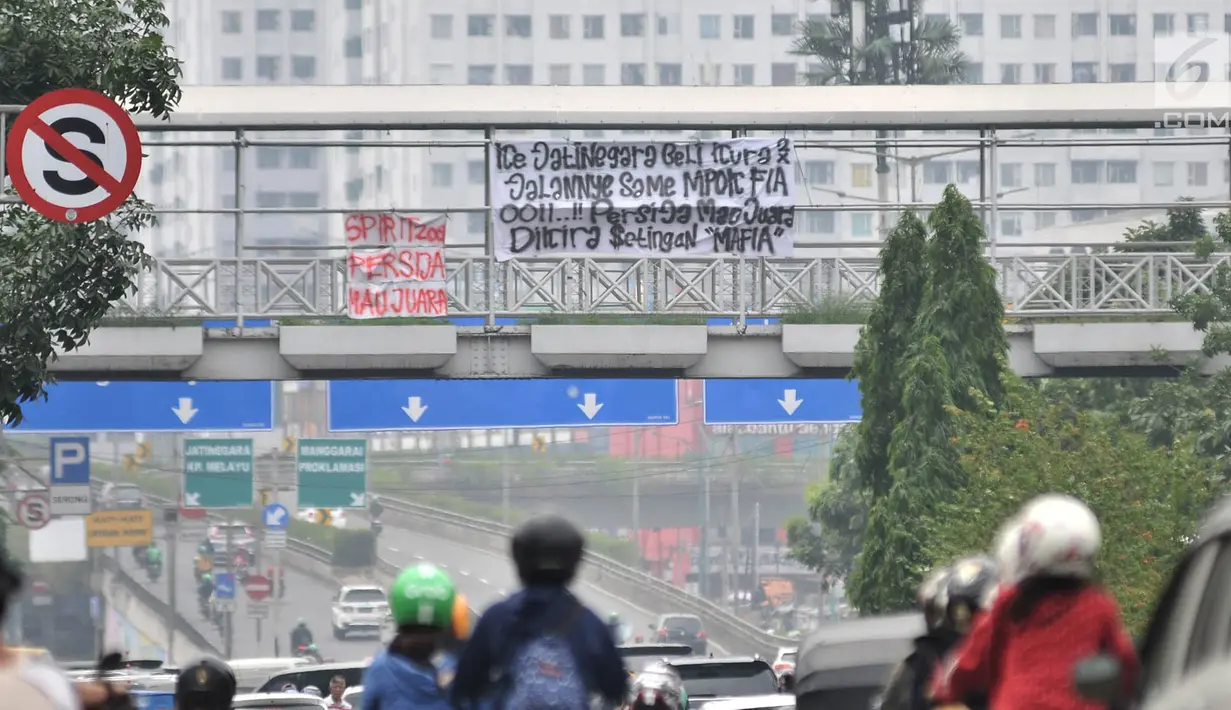 Spanduk dukungan Persija yang terpasang di JPO, Jakarta, Minggu (9/12). Dalam spanduk tersebut bertuliskan berbagai ungkapan dukungan dan doa para The Jakmania agar Persija menjadi juara Liga 1 2018. (Merdeka.com/Iqbal S. Nugroho)