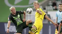 Pemain Borussia Dortmund, Erling Haaland, berebut bola dengan pemain Wolfsburg, Xaver Schlager, pada laga Bundesliga, Minggu (24/5/2020). Borussia Dortmund menang 2-0 atas Wolfsburg. (AP/Michael Sohn)