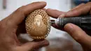 Zhang Xiaohe membuat kerajinan ukiran telur di sebuah lokakarya warisan budaya takbenda di Shijiangzhuang, China pada 17 April 2020. Ukiran telur sering disebut "seni yang paling rapuh", karena membutuhkan ketelitian dan perhatian tinggi sebelum, selama dan setelah pembuatannya. (Xinhua/Chen Qibao)