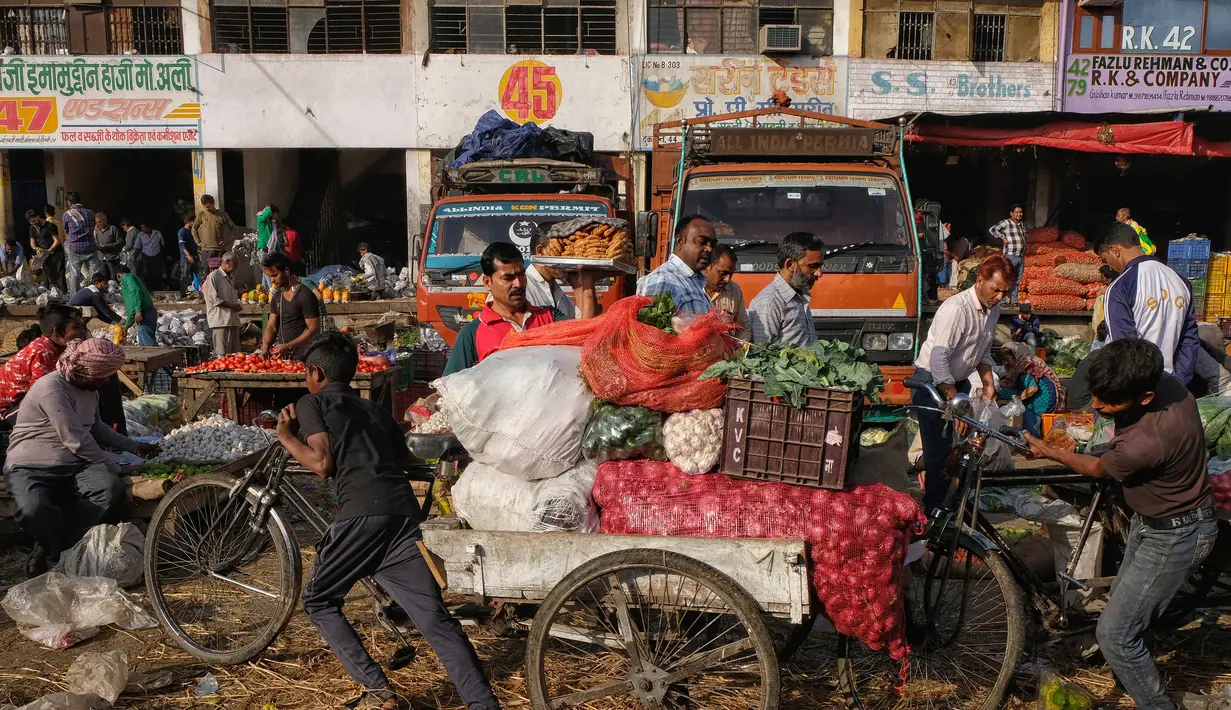Seorang pekerja muda menarik sayuran di atas becaknya di pasar grosir buah dan sayuran di New Delhi, India (27/3). Delhi telah sejak zaman sejarah tetap menjadi tujuan favorit bagi pembeli. (AFP Photo/Noemi Cassanelli)
