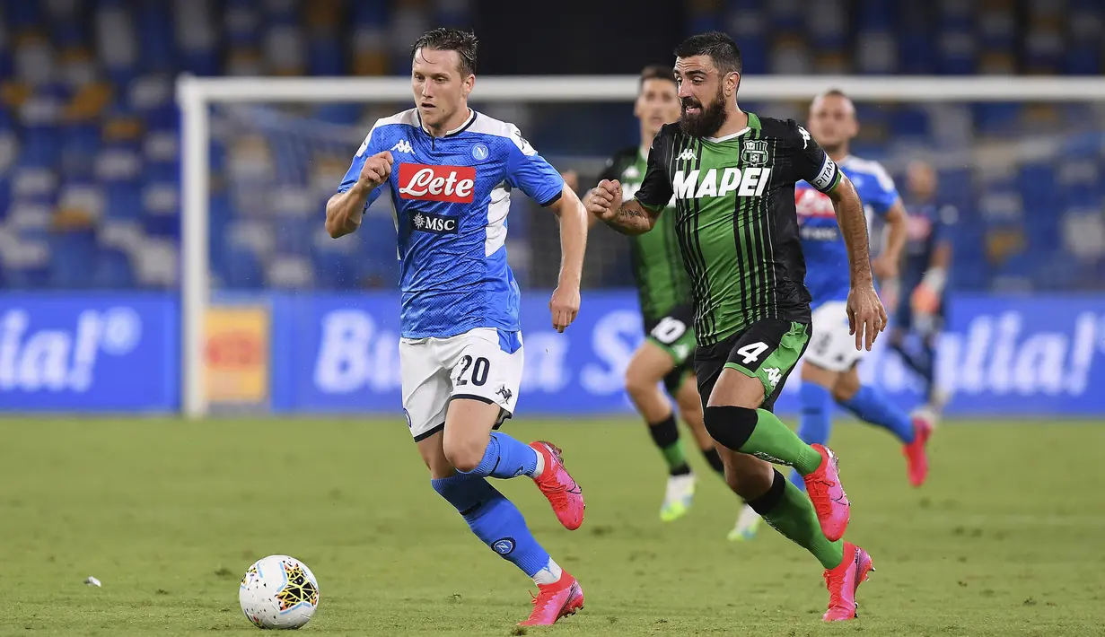 Pemain Napoli Piotr Zielinski (kiri) dan pemain Sassuolo Francesco Manganelli berebut bola pada pertandingan Serie A di Stadion San Paolo, Naples, Italia, Sabtu (25/7/2020). Napoli mengalahkan Sassuolo dengan skor 2-0. (Cafaro/LaPresse via AP)