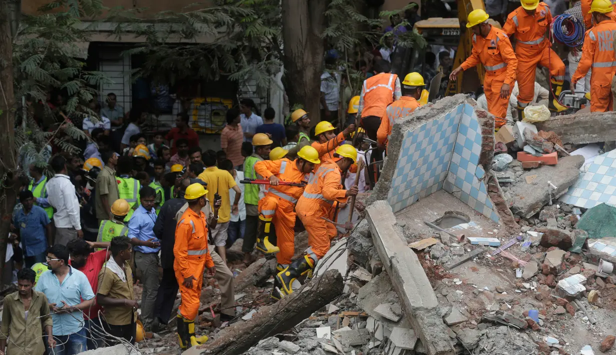 Tim penyelamat mencari korban lainnya dalam puing-puing bangunan di Mumbai, India, Selasa (25/7). Sebuah gedung penghunian lima lantai runtuh pada selasa pagi waktu setempat. (AP/Rafiq Maqbool) 
